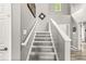 Carpeted staircase with white railing and gray walls at 10697 Woodmont Ln, Fishers, IN 46037