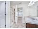 Bright bathroom featuring a shower, single sink vanity with marble countertop, and access to the bedroom at 107 Elliott Ave, Trafalgar, IN 46181