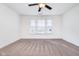 Carpeted room with a ceiling fan and large windows providing natural light at 107 Elliott Ave, Trafalgar, IN 46181