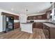 Bright kitchen with brown cabinets, stainless steel sink, and an island with pendant lighting at 107 Elliott Ave, Trafalgar, IN 46181