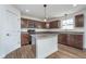 Spacious kitchen featuring wood-look flooring, stainless steel appliances, and a functional center island at 107 Elliott Ave, Trafalgar, IN 46181