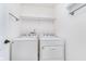 Functional laundry room with a washer, dryer, and overhead shelving for storage and organization at 107 Elliott Ave, Trafalgar, IN 46181
