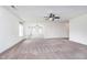Expansive living room featuring neutral carpeting, fan, and large windows at 107 Elliott Ave, Trafalgar, IN 46181