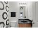 Cozy bathroom featuring a vanity with a black countertop and modern wallpaper at 10722 Landsbrook N Run, Noblesville, IN 46060