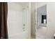 Bright bathroom featuring a tub and shower combo, with an open door to another room at 10722 Landsbrook N Run, Noblesville, IN 46060