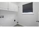 Neat laundry room features white cabinets, neutral wall paint, and a window with privacy shades at 10722 Landsbrook N Run, Noblesville, IN 46060