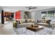 Bright living room with modern sofas, ceiling fan, and stylish rug adjacent to a kitchen with stainless appliances at 10722 Landsbrook N Run, Noblesville, IN 46060