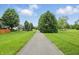 View of the paved walking path, bordered by green grass and mature trees at 10722 Landsbrook N Run, Noblesville, IN 46060