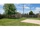 Large backyard with a grassy lawn, wooden fence, storage shed, and concrete patio area at 1129 Central Park S Blvd, Greenwood, IN 46143