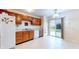 Well-lit kitchen with wooden cabinetry, white appliances, and a sliding glass door to the backyard at 1129 Central Park S Blvd, Greenwood, IN 46143
