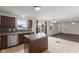 Well-lit eat-in kitchen with modern appliances, tile backsplash, and a kitchen island, with a view to backyard at 11531 Short Iron Ln, Indianapolis, IN 46235