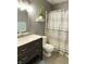 Bathroom features a modern vanity with sink, toilet, and neutral shower curtain at 12231 Valley View Cir, Indianapolis, IN 46229