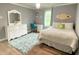 Bright bedroom features a comfy bed, a white vanity, and a fun accent surfboard at 12231 Valley View Cir, Indianapolis, IN 46229