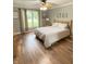 Cozy bedroom with hardwood floors, a ceiling fan, and a bright window overlooking the yard at 12231 Valley View Cir, Indianapolis, IN 46229