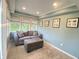 Inviting sunroom features a comfortable couch, ottoman, large windows, and neutral decor at 12231 Valley View Cir, Indianapolis, IN 46229