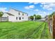 Large backyard with a lush green lawn, privacy fence, and a white house exterior at 1234 Breaside Cir, Greenwood, IN 46143