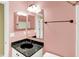 Bathroom with a single sink vanity featuring black granite countertops against a pink wall backdrop at 1234 Breaside Cir, Greenwood, IN 46143