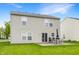 Back exterior view with a patio and table and chairs; well-maintained lawn and light siding at 12444 Bearsdale Dr, Indianapolis, IN 46235