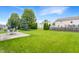 Spacious backyard with mature trees, a patio with a table and chairs, and a wooden fence at 12444 Bearsdale Dr, Indianapolis, IN 46235