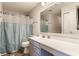 Bright bathroom featuring vanity with a large mirror and shower with blue curtain at 12444 Bearsdale Dr, Indianapolis, IN 46235