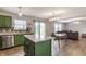 Modern kitchen showcasing green cabinets, a stainless steel dishwasher, and an island with a seating area at 12444 Bearsdale Dr, Indianapolis, IN 46235