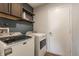 Functional laundry room with modern washer and dryer, plus upper cabinets for storage at 12444 Bearsdale Dr, Indianapolis, IN 46235