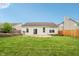 This backyard shows a home with a lawn, wood fence, and some landscaping at 12496 Wolf Run Rd, Noblesville, IN 46060