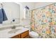 Bright bathroom featuring floral shower curtain, neutral tile, a framed mirror, and great lighting at 12496 Wolf Run Rd, Noblesville, IN 46060