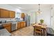 Functional kitchen with stainless steel appliances, wooden cabinetry, and a dining area with tile floors at 12496 Wolf Run Rd, Noblesville, IN 46060