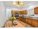 Warm kitchen with stainless appliances, tile floor, wood cabinets, and adjacent dining table with charming lighting at 12496 Wolf Run Rd, Noblesville, IN 46060