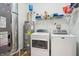 Well-organized laundry area with a washer, dryer, hot water tank, and ample storage shelves at 12496 Wolf Run Rd, Noblesville, IN 46060