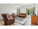 Bright living room with sliding glass doors, wood-look flooring, and comfortable seating, ideal for relaxation at 12496 Wolf Run Rd, Noblesville, IN 46060