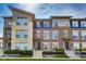 Modern townhouse featuring a combination of brick and stone facade, complemented by well-manicured landscaping at 13050 Grand Vue Dr, Carmel, IN 46032