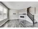 Open living room featuring modern fireplace, staircase, and large window for natural light at 13050 Grand Vue Dr, Carmel, IN 46032