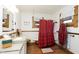 Bright bathroom featuring a classic tub, decorative mirror, and wood-look tile floor at 1352 Clinton St, Noblesville, IN 46060