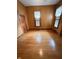Bright bedroom featuring gleaming hardwood floors, two windows, and a classic wooden door at 1352 Clinton St, Noblesville, IN 46060