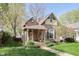 Quaint home showcasing a covered porch, American flag, and a lush green lawn at 1352 Clinton St, Noblesville, IN 46060