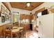 Quaint kitchen featuring wood-paneled ceiling and walls, updated appliances, and an adjacent dining area at 1352 Clinton St, Noblesville, IN 46060
