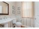 Charming half bathroom featuring classic fixtures and decorative wallpaper at 13693 Cunningham Dr, Carmel, IN 46074
