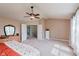 Bright bedroom featuring neutral walls, carpet, ceiling fan, and white doors leading to other rooms at 13693 Cunningham Dr, Carmel, IN 46074