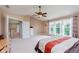 Bright bedroom featuring neutral walls, carpet, ceiling fan, and large window with patterned curtains at 13693 Cunningham Dr, Carmel, IN 46074