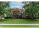 Beautiful brick home with a manicured lawn and mature trees providing shade and curb appeal at 13693 Cunningham Dr, Carmel, IN 46074