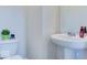 Bathroom features a pedestal sink, modern fixtures, and a nearby toilet at 1529 Fairmount Dr, Greenfield, IN 46140