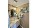 Cozy half-bath showcasing stylish decor, a round mirror, and a charming vanity with a sink at 1831 Beckenbauer Ln, Indianapolis, IN 46214
