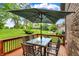 Inviting back deck features an outdoor dining area with a glass-topped table and umbrella overlooking the lush backyard at 1850 Longest Dr, Franklin, IN 46131