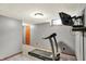 Finished basement includes a ceiling light and a wall-mounted television over a treadmill at 1850 Longest Dr, Franklin, IN 46131