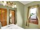 A well-lit bathroom featuring a white vanity, a window, and a view into another room at 1850 Longest Dr, Franklin, IN 46131