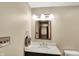 Bathroom featuring a dark vanity, marble countertop, an elegant framed mirror, and modern fixtures at 1850 Longest Dr, Franklin, IN 46131