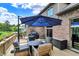 Outdoor deck with a dining set, grill, and a beautiful blue umbrella overlooking the lush green backyard at 1850 Longest Dr, Franklin, IN 46131