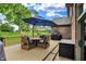 Outdoor deck furnished with a dining set, grill, and a beautiful blue umbrella overlooking the backyard at 1850 Longest Dr, Franklin, IN 46131